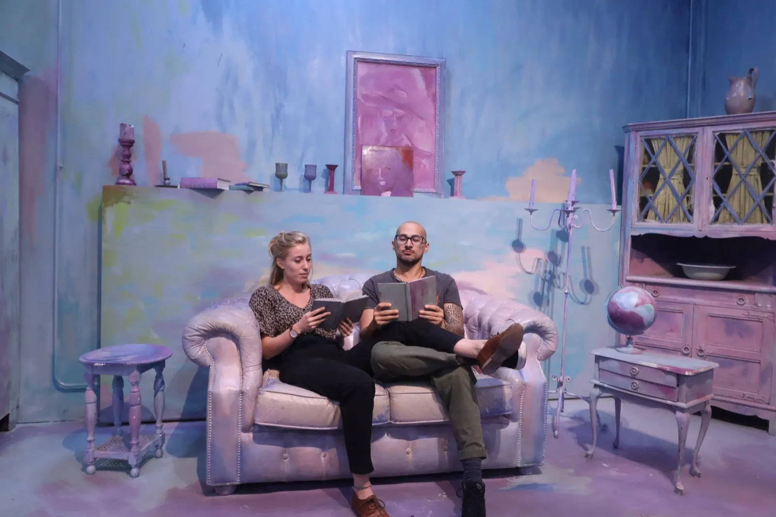 Anne and David reading together in a pastel art room.
