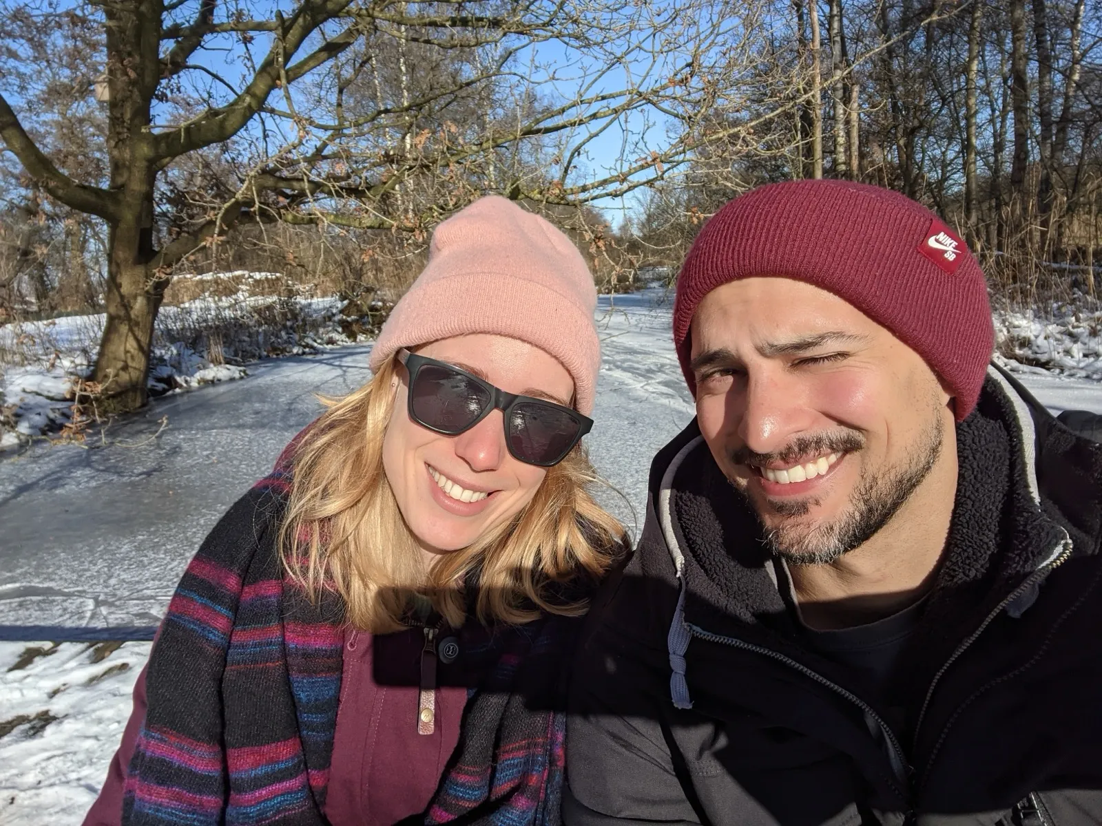 Anne and David smiling on a frozen canal in winter.