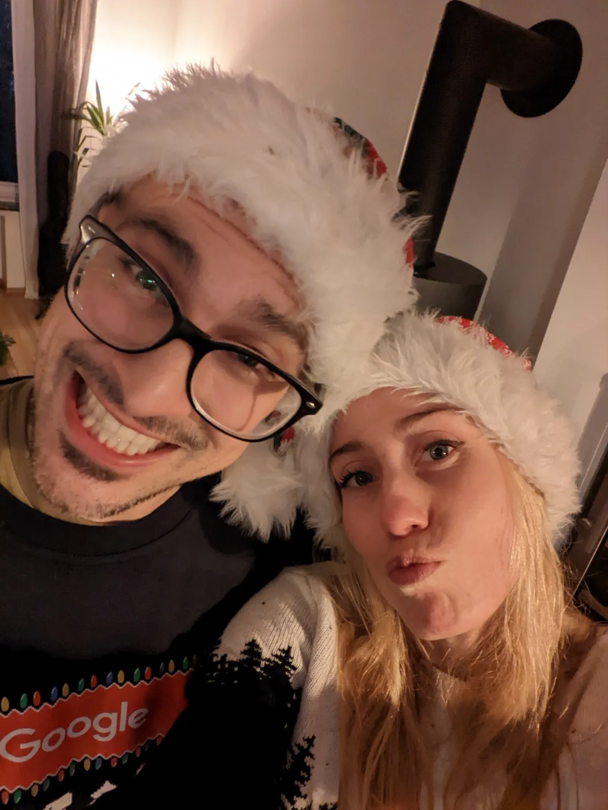 Anne and David in Santa hats, cozy Christmas selfie.